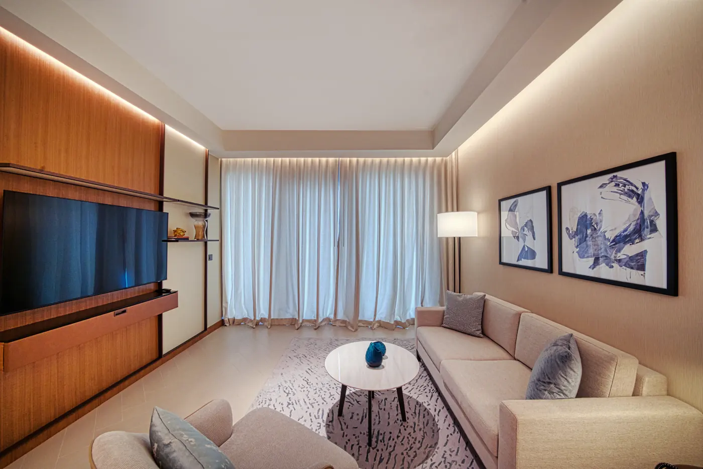 Hotel living room interior with framed wall art and soft furnishings