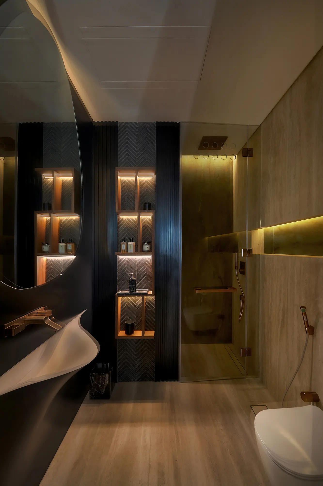 Contemporary bathroom interior with dark tile, marble and brass fittings