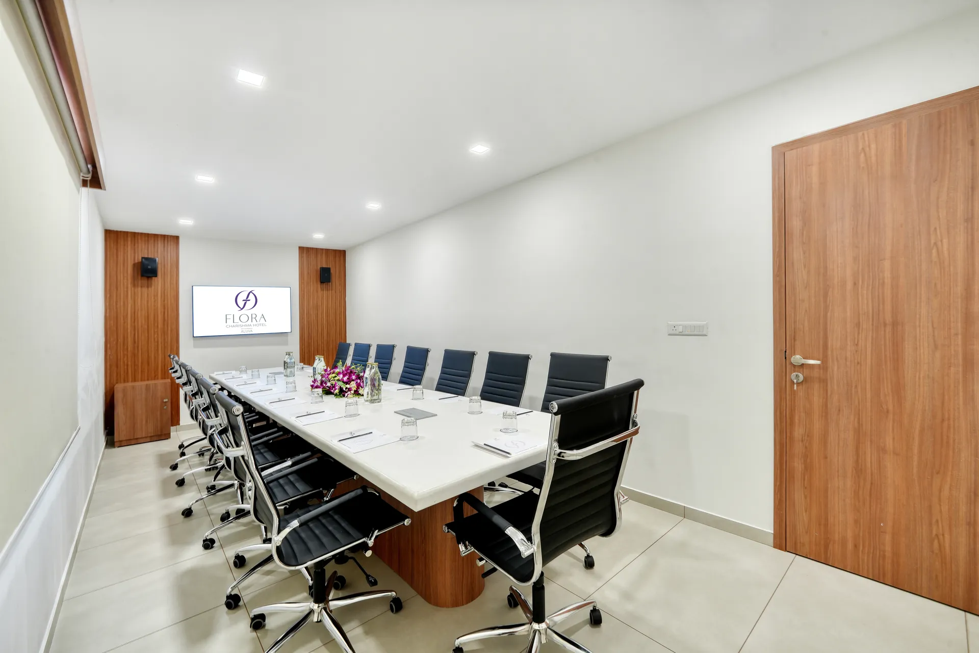 Banglore Hotel conference room with wooden door and long white boardroom table — hotel properties shot in Kochi, Kerala, Bengaluru (Bangalore)