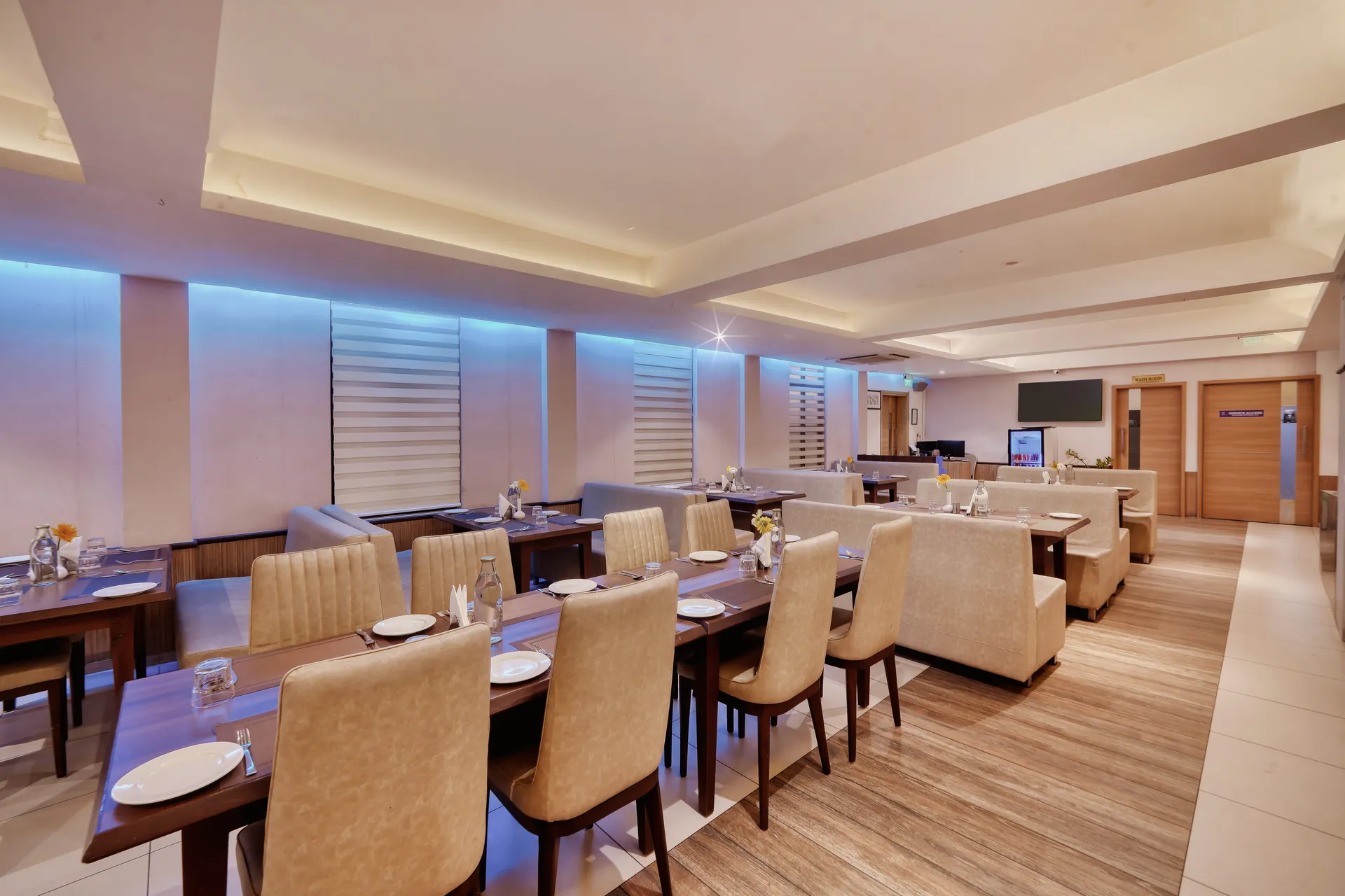 Hotel restaurant interior with banquette seating, wooden flooring and blue cove lighting — hotel properties shot in Kochi, Kerala, Bengaluru (Bangalore)