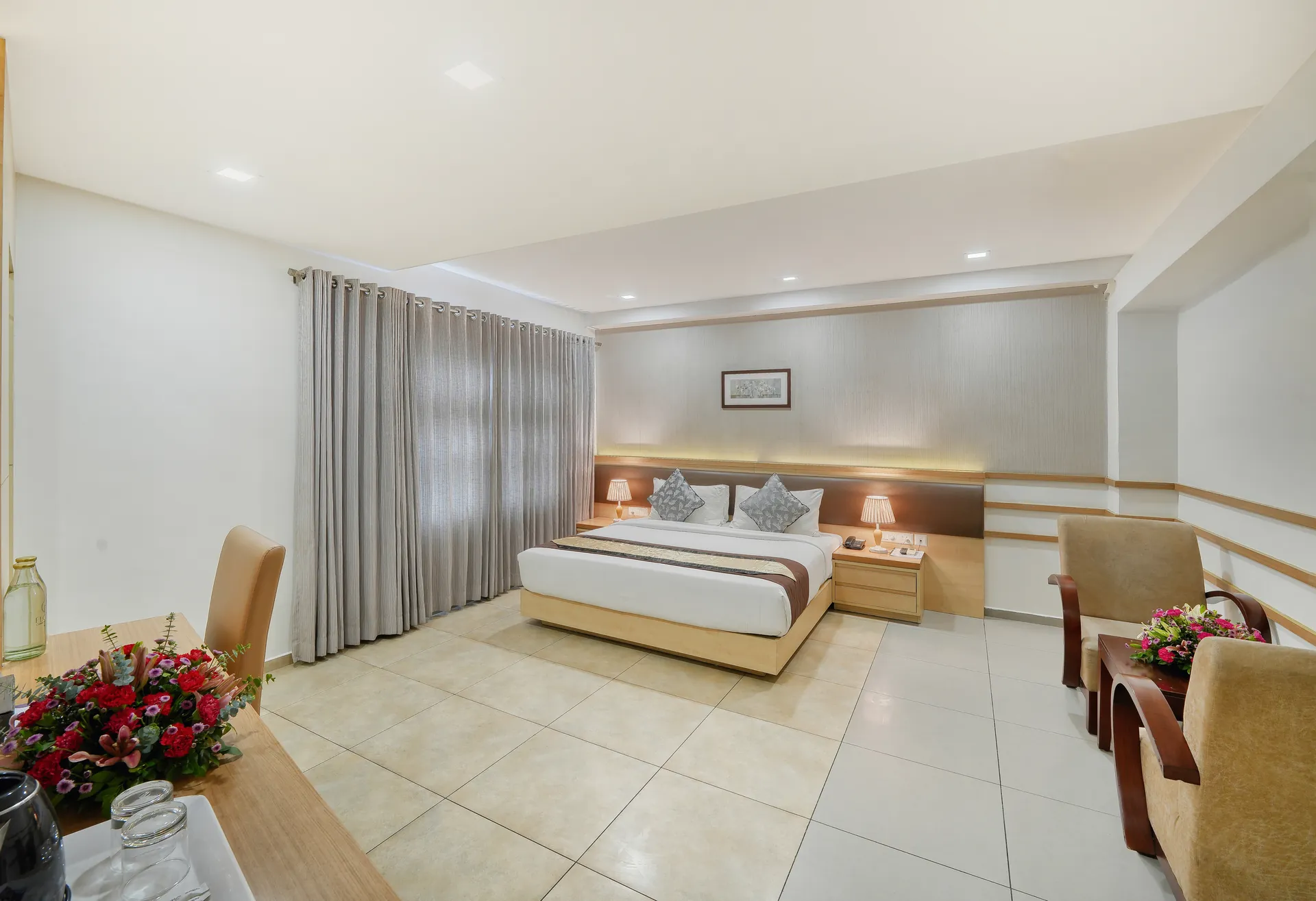 spacious hotel room with lounge chairs and fresh flowers, Flora Charishma Hotel, Aluva, Kochi, Kerala