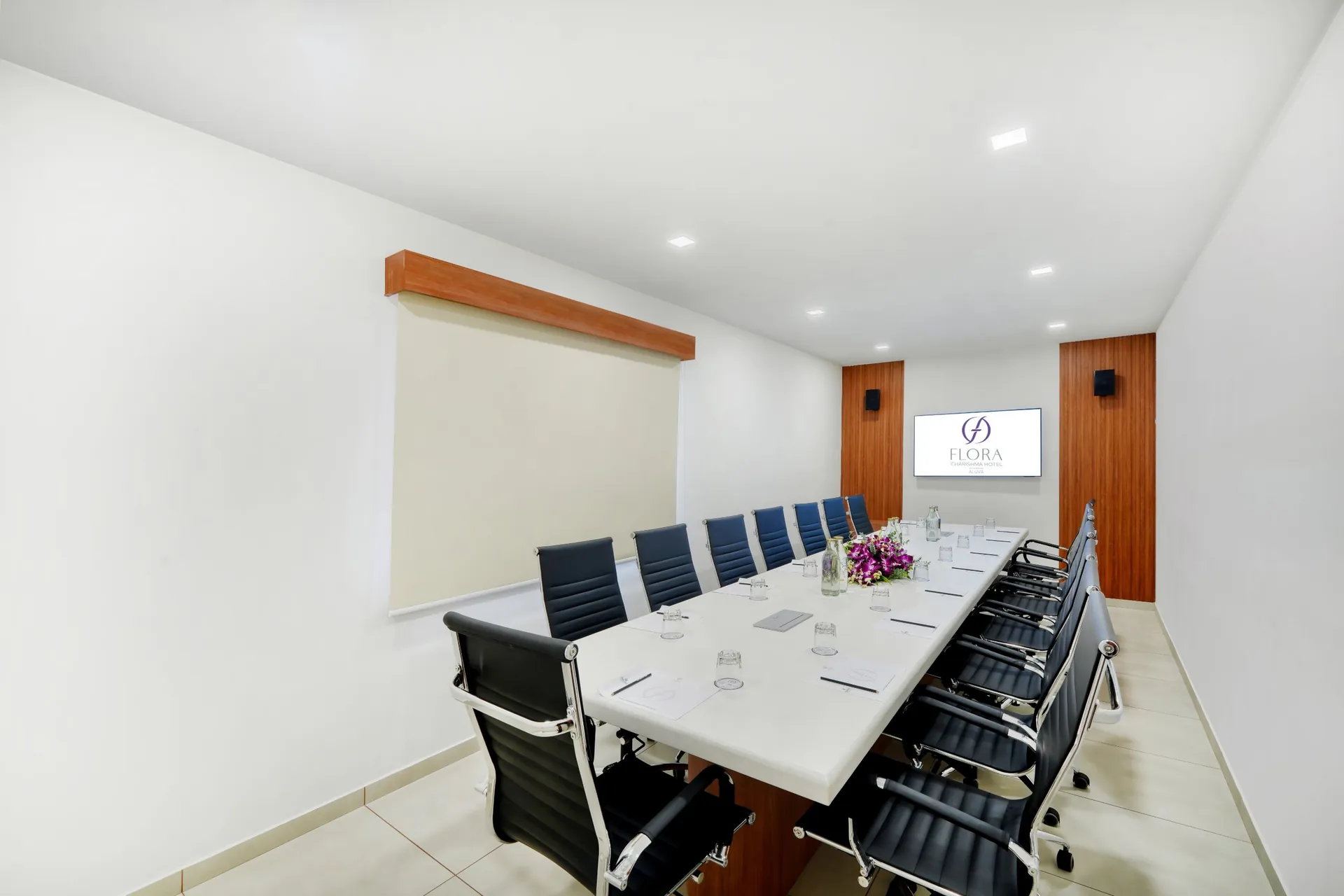 Bengaluru | Banglore Hotel boardroom with white conference table, black leather chairs and wall screen — hotel properties shot in Kochi, Kerala, Bengaluru (Bangalore)