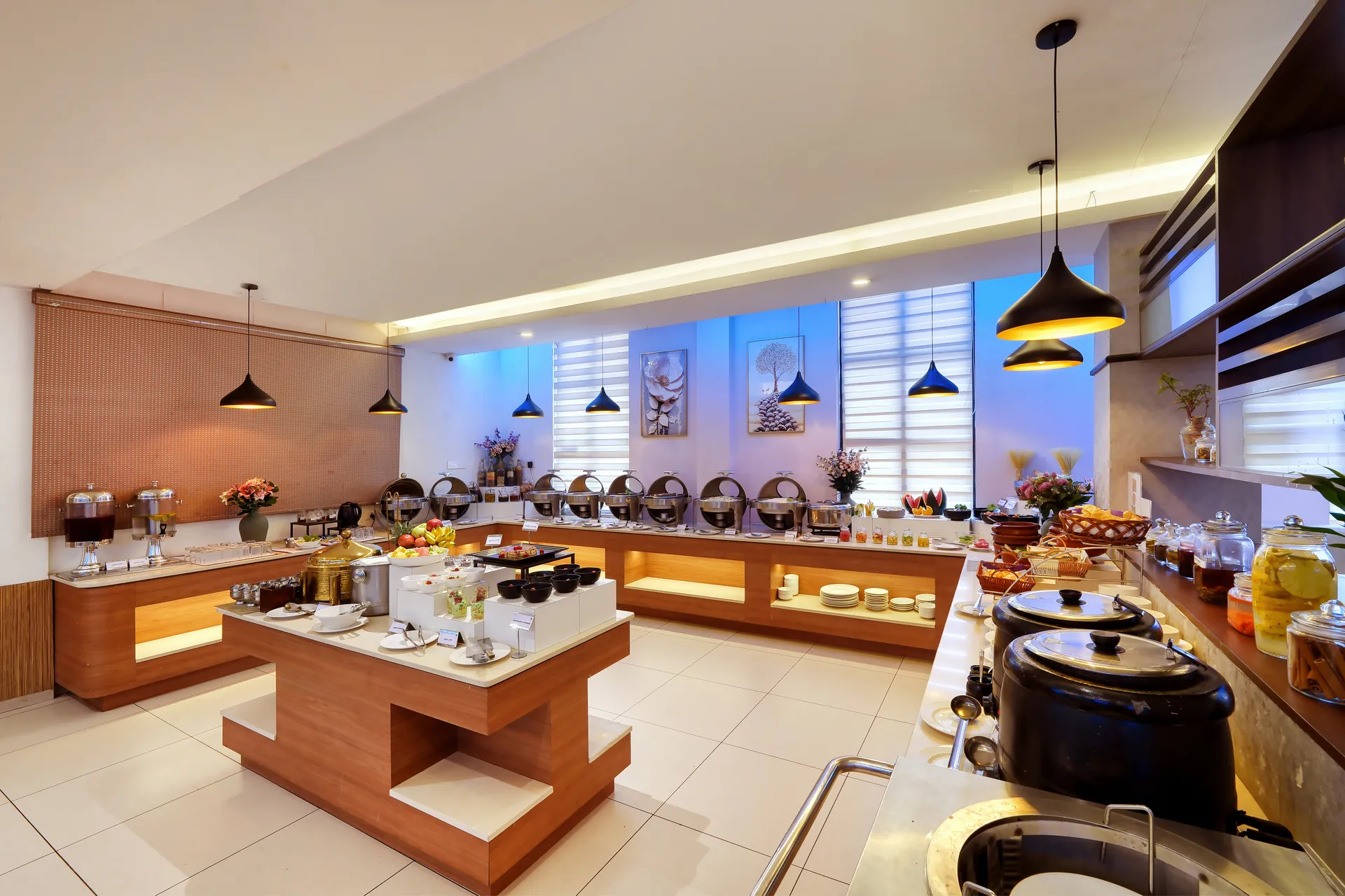 Hotel buffet station with warm wood counters, pendant lights and live food displays — hotel properties shot in India, Kochi, Kerala, Bengaluru (Bangalore)