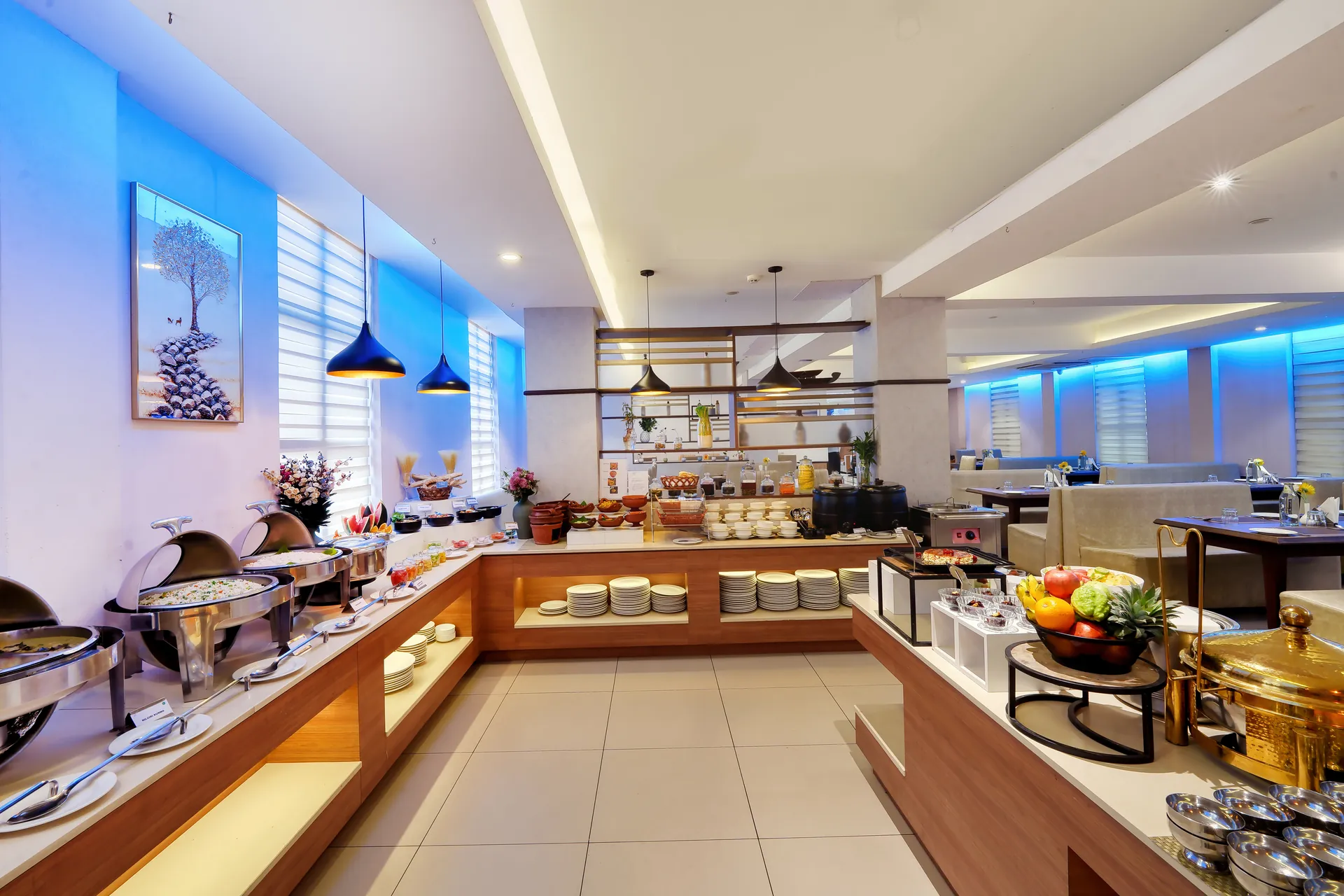 Hotel breakfast buffet counter with chafing dishes, fruit display and pendant lights — hotel properties shot in Kochi, Kerala, Bengaluru (Bangalore)