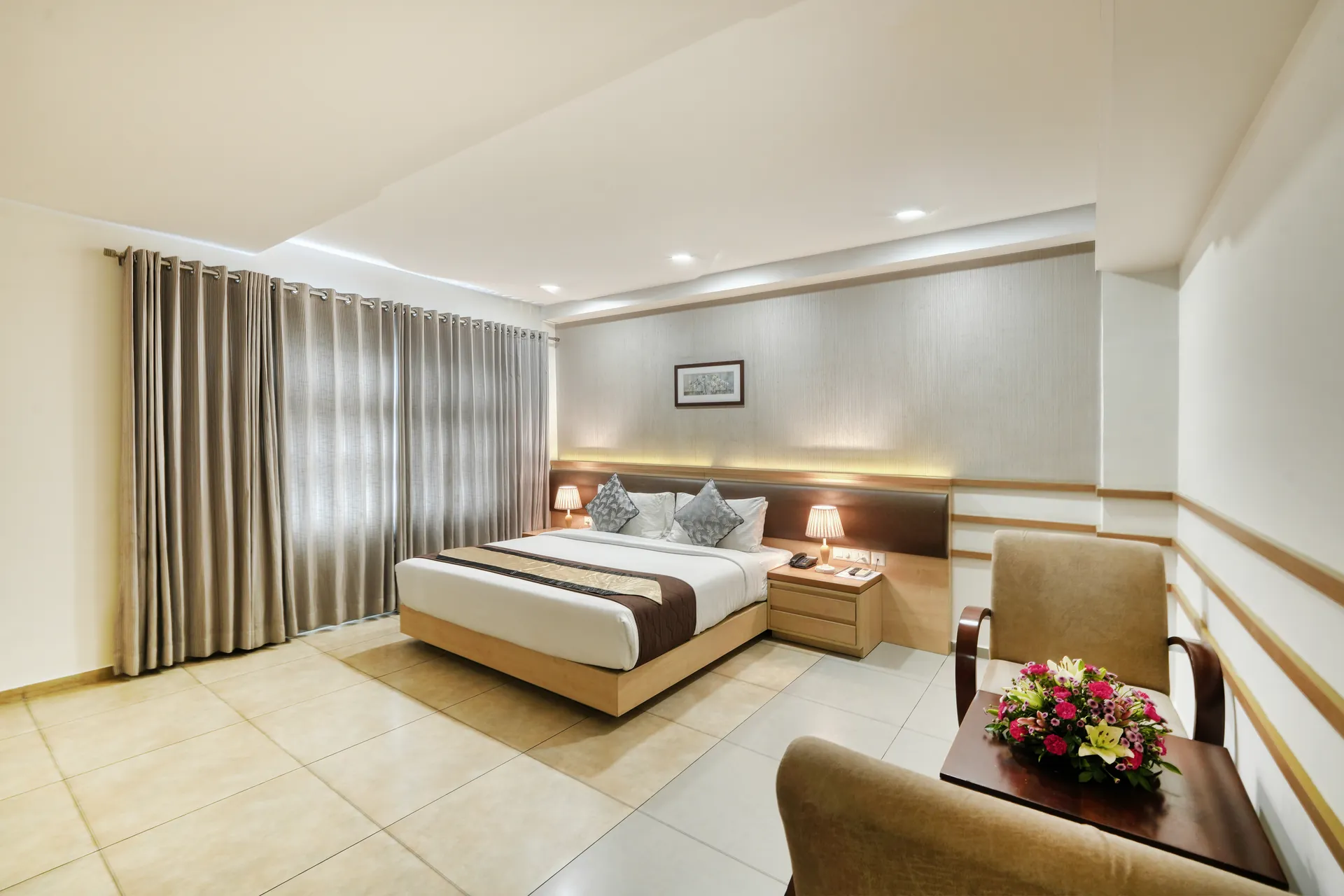 Deluxe hotel king room with armchairs, flower arrangement and soft cove lighting — hotel properties shot in Kochi, Kerala, Bengaluru (Bangalore)